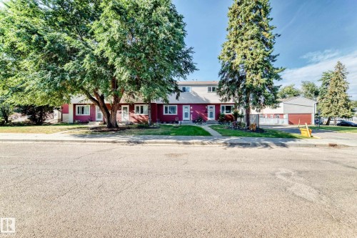 Two-story townhouse with red siding and white trim - 44 Habitat Crescent Nw, Edmonton, AB 