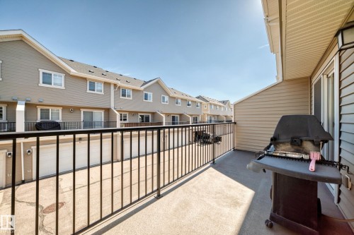 Private balcony with concrete flooring, black metal railing, and direct access to a sliding glass door - #39 7289 South Terwillegar Nw, Edmonton, AB 