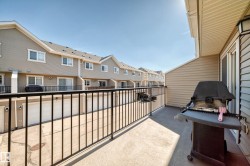 Private balcony with concrete flooring, black metal railing, and direct access to a sliding glass door - 