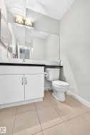 White vanity with dual-door cabinetry, black countertop, and a full-width mirror - 