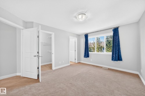 Generous window with white trim, wall-to-wall carpeting, and a built-in closet with shelving - #39 7289 South Terwillegar Nw, Edmonton, AB 