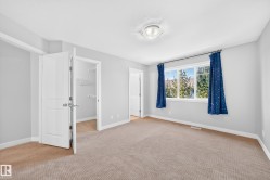 Generous window with white trim, wall-to-wall carpeting, and a built-in closet with shelving - 