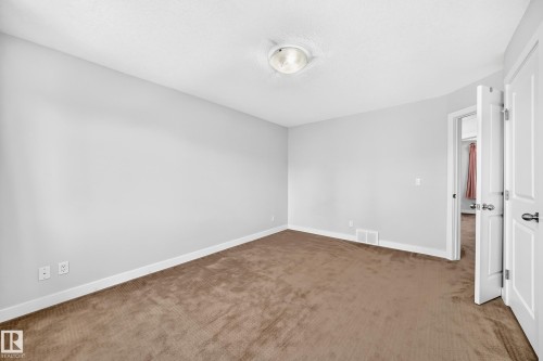 Neutral wall paint with textured carpeting, accompanied by a flush-mount ceiling light fixture - #39 7289 South Terwillegar Nw, Edmonton, AB 