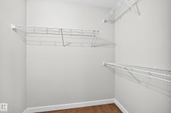 Interior closet featuring wire shelving and wood-finish flooring - 