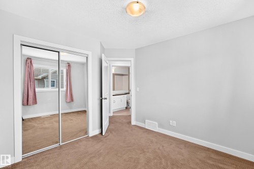 Mirrored sliding closet doors, wall-to-wall carpeting, and neutral paint - #39 7289 South Terwillegar Nw, Edmonton, AB 