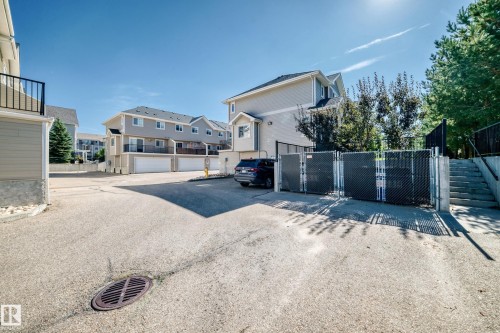 Paved common area with chain-link fencing and mature trees - #39 7289 South Terwillegar Nw, Edmonton, AB 