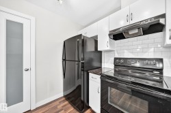 Dark wood-finish flooring complements the white cabinetry and white subway tile backsplash - 