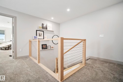 Carpeted landing featuring a wooden and cable railing system, recessed lighting, and built-in floating shelves - 49279 Rge Rd 240, Rural Leduc County, AB 