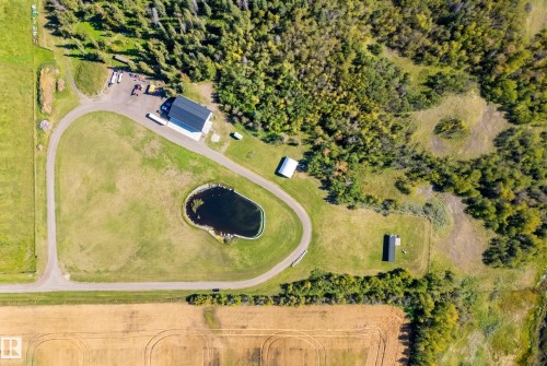 Expansive property featuring a paved driveway, natural pond, and a large outbuilding - 49279 Rge Rd 240, Rural Leduc County, AB 