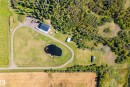 Expansive property featuring a paved driveway, natural pond, and a large outbuilding - 49279 Rge Rd 240, Rural Leduc County, AB 