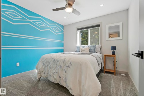 Patterned accent wall, recessed ceiling lighting, ceiling fan with light, window with dark trim, and gray carpet - 49279 Rge Rd 240, Rural Leduc County, AB 