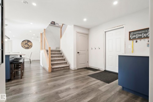 Wood-finish flooring, recessed lighting, and a staircase with wood railing and carpeted treads - 49279 Rge Rd 240, Rural Leduc County, AB 