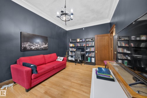 Hardwood-finish flooring, built-in shelving, crown molding, and a chandelier-style light fixture - 719 65 Ave Nw, Edmonton, AB 