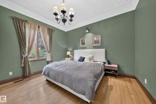Hardwood flooring, crown molding, a decorative ceiling, a window with trim, and a chandelier - 719 65 Ave Nw, Edmonton, AB 