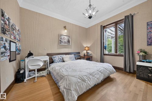 Hardwood flooring, crown molding, striped wall covering, wood-framed window, and chandelier - 719 65 Ave Nw, Edmonton, AB 