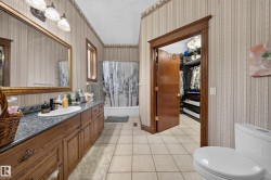 Expansive vanity with a single sink, an ornate framed mirror, and a three-light fixture - 