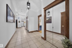 Hallway featuring square tile flooring, decorative ceiling, and dark wood trim - 