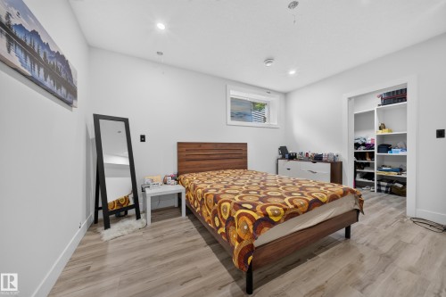 Recessed ceiling lighting, wood-finish flooring, built-in open shelving, and a single window - 719 65 Ave Nw, Edmonton, AB 