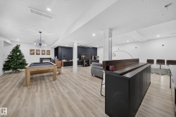 Recessed lighting, wood-finish flooring, and a built-in bar with dark cabinetry - 