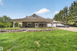 Single-story residence featuring a covered porch, multiple garage bays, and a dormer window - 