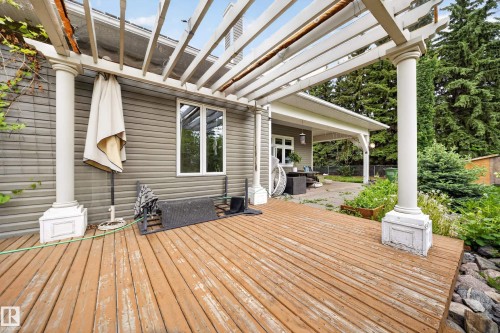 Wood-finish deck with a white pergola, offering an outdoor living space - 719 65 Ave Nw, Edmonton, AB 