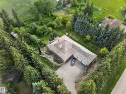L-shaped property with a multi-car garage, surrounded by mature evergreen trees - 