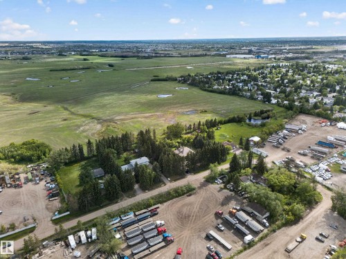 Expansive green fields, wooded areas, and a visible pond - 719 65 Ave Nw, Edmonton, AB 
