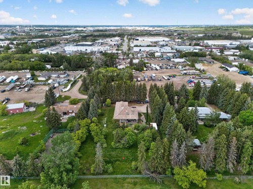 Expansive treed property with a residential structure, surrounded by established greenery - 719 65 Ave Nw, Edmonton, AB 
