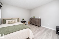 Light-toned wood-finish flooring, neutral wall tones, and a window with roller shades - 