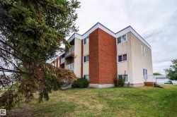 Multi-level building with brick and stucco exterior, white trim, and multiple balconies with white railings - 