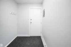 Entryway featuring white painted walls and patterned floor covering - 