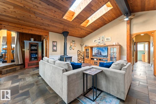 Vaulted wood-paneled ceiling with skylights, wood-burning stove, and slate-style floor tiling - #421 61209 Rge Rd 465, Rural Bonnyville M.D., AB 