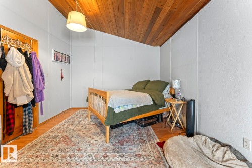Wood-paneled ceiling with a sloped design, wood-finish flooring, and white painted walls - #421 61209 Rge Rd 465, Rural Bonnyville M.D., AB 