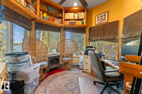 Built-in natural wood shelving, multiple windows with natural scenery, and a ceiling fan with wood-finish blades - #421 61209 Rge Rd 465, Rural Bonnyville M.D., AB 