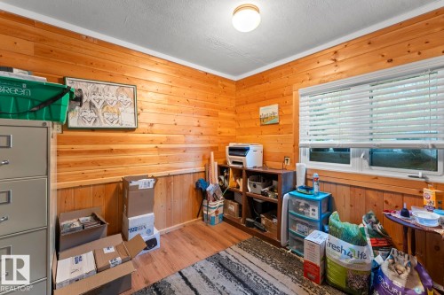 Wood-paneled walls with wainscoting, wood-finish flooring, and white window blinds - #421 61209 Rge Rd 465, Rural Bonnyville M.D., AB 