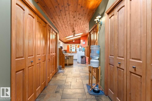Wood-finish bi-fold doors, wood-paneled ceiling, recessed lighting, and tile flooring - #421 61209 Rge Rd 465, Rural Bonnyville M.D., AB 