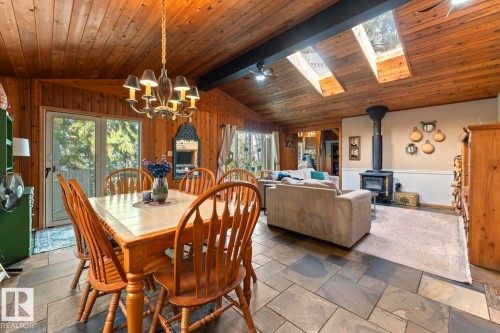 Wood-paneled vaulted ceiling with exposed beams, multiple skylights, and a wood-burning stove - #421 61209 Rge Rd 465, Rural Bonnyville M.D., AB 