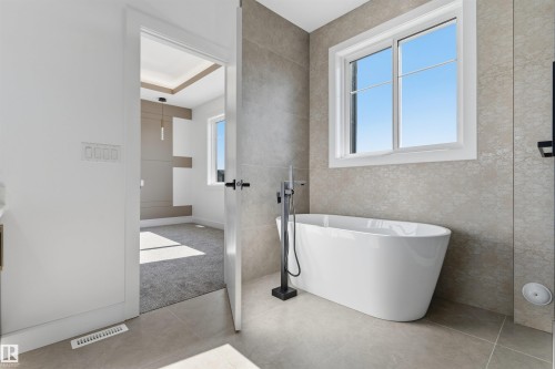 Freestanding soaking tub with a floor-mounted matte black faucet - 2720 63 Avenue, Rural Leduc County, AB 