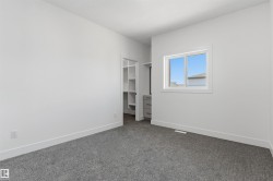 Grey carpeted flooring, white walls, and a window with white trim - 