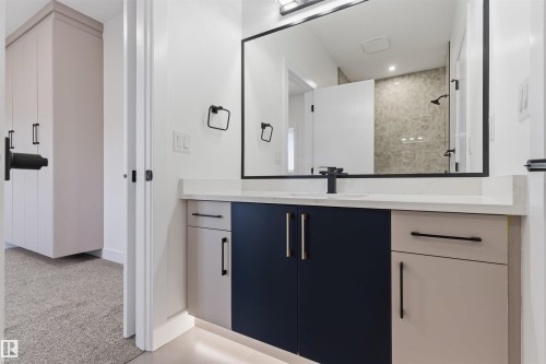 Floating vanity with a light-colored countertop, integrated sink, and matte black faucet - 2720 63 Avenue, Rural Leduc County, AB 