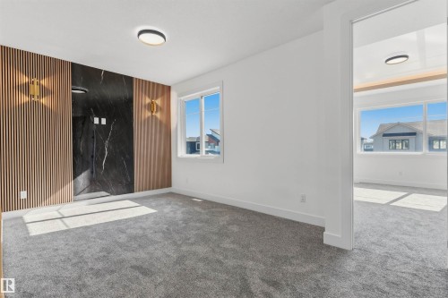 Accent wall featuring wood-finish paneling and black stone-finish material - 2720 63 Avenue, Rural Leduc County, AB 