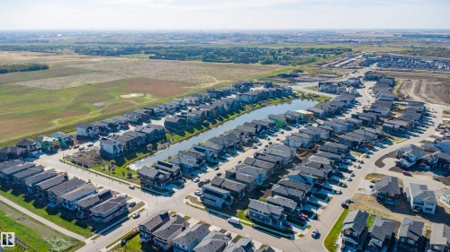 Residential community featuring a central pond, paved streets, and a mix of single-family homes and townhomes - 2720 63 Avenue, Rural Leduc County, AB 