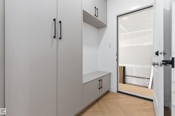Built-in cabinetry with matte black hardware, integrated shelving, and a built-in bench - 