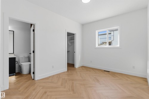 Herringbone wood-finish flooring, white walls, and a single window provide natural light - 2720 63 Avenue, Rural Leduc County, AB 