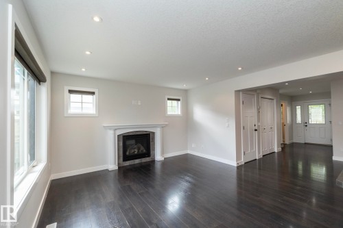 Recessed lighting, wood-finish flooring, a fireplace with a stone surround, and multiple windows - 55 Michigan Street, Devon, AB 
