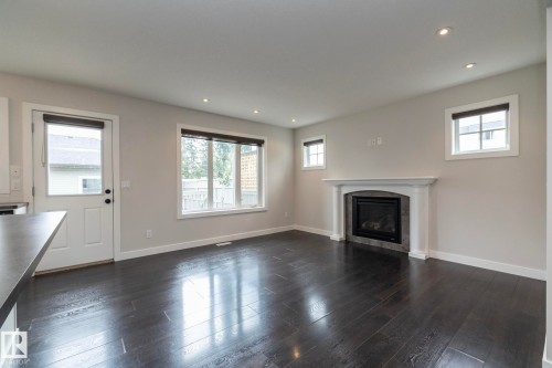 Wood-finish flooring, recessed lighting, and a white mantel fireplace with tile surround - 55 Michigan Street, Devon, AB 