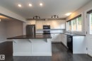 Kitchen featuring a central island, white cabinetry, dark countertops, and stainless steel appliances - 55 Michigan Street, Devon, AB 