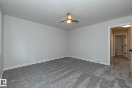 Plush gray carpeting, light gray walls, and a ceiling fan with integrated lighting - 55 Michigan Street, Devon, AB 
