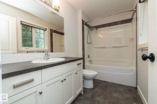 White shaker vanity with a dark countertop and integrated sink - 55 Michigan Street, Devon, AB 