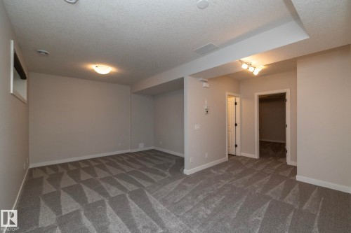 Spacious room with patterned carpet, recessed lighting, and track lighting fixtures - 55 Michigan Street, Devon, AB 